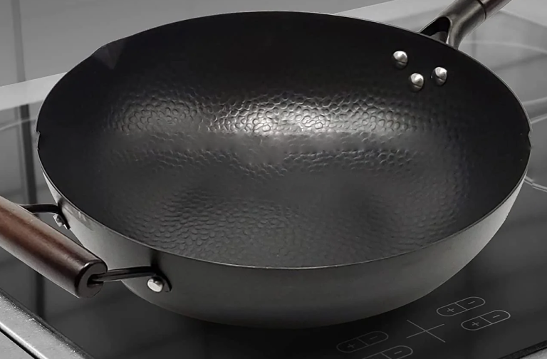 Stalen wokpan met een ronde bodem voor gebruik op een inductie kookplaat
